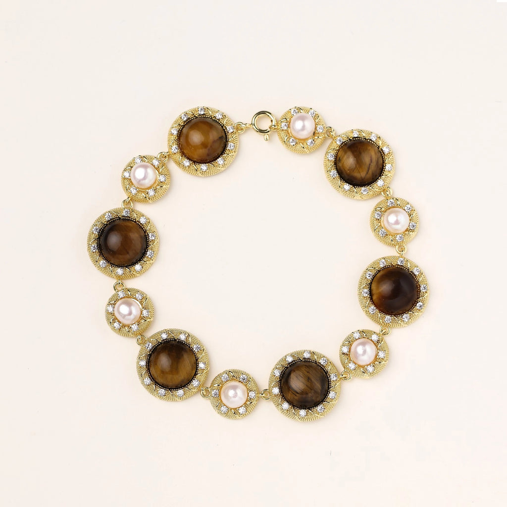 Ornate gold-plated bracelet with alternating brown tiger's eye stones and white freshwater pearls in crystal-accented settings