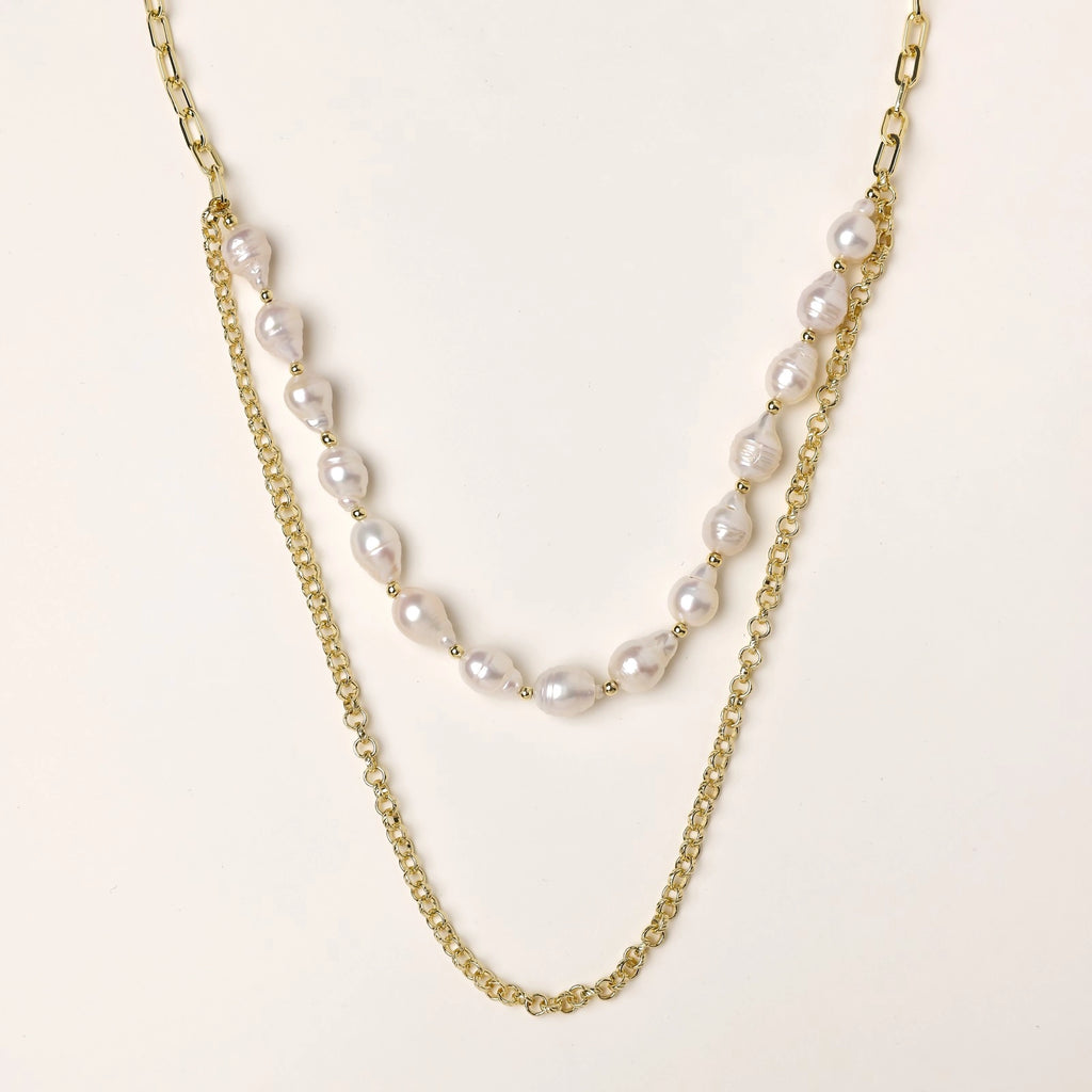 Layered gold chain necklace with irregular freshwater pearls on cream background, showing adjustable dual-strand design.