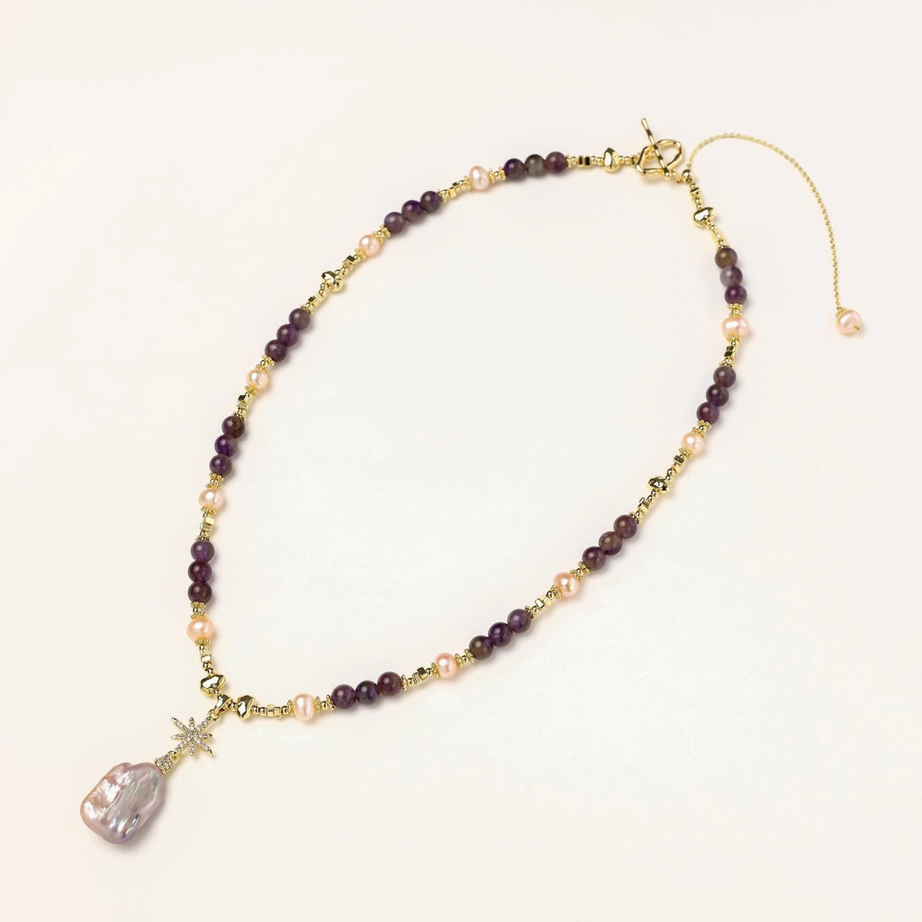 Gold-plated necklace with purple amethyst beads, pink pearls, and iridescent baroque pearl pendant beneath crystal star charm