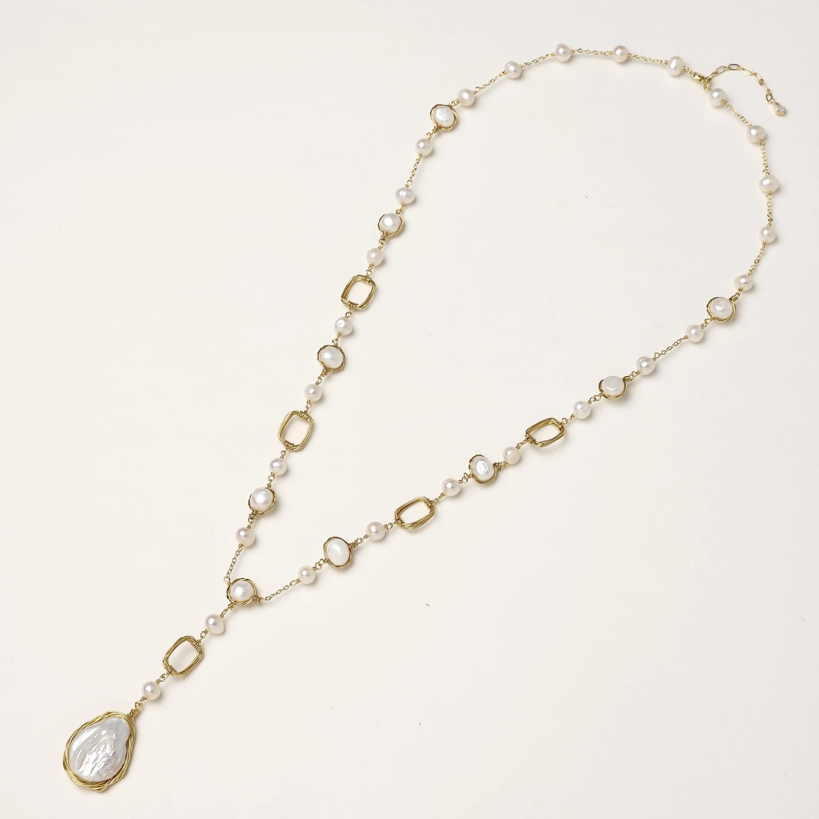Y-shaped gold-plated necklace with freshwater pearls and geometric elements, featuring a baroque pearl pendant drop