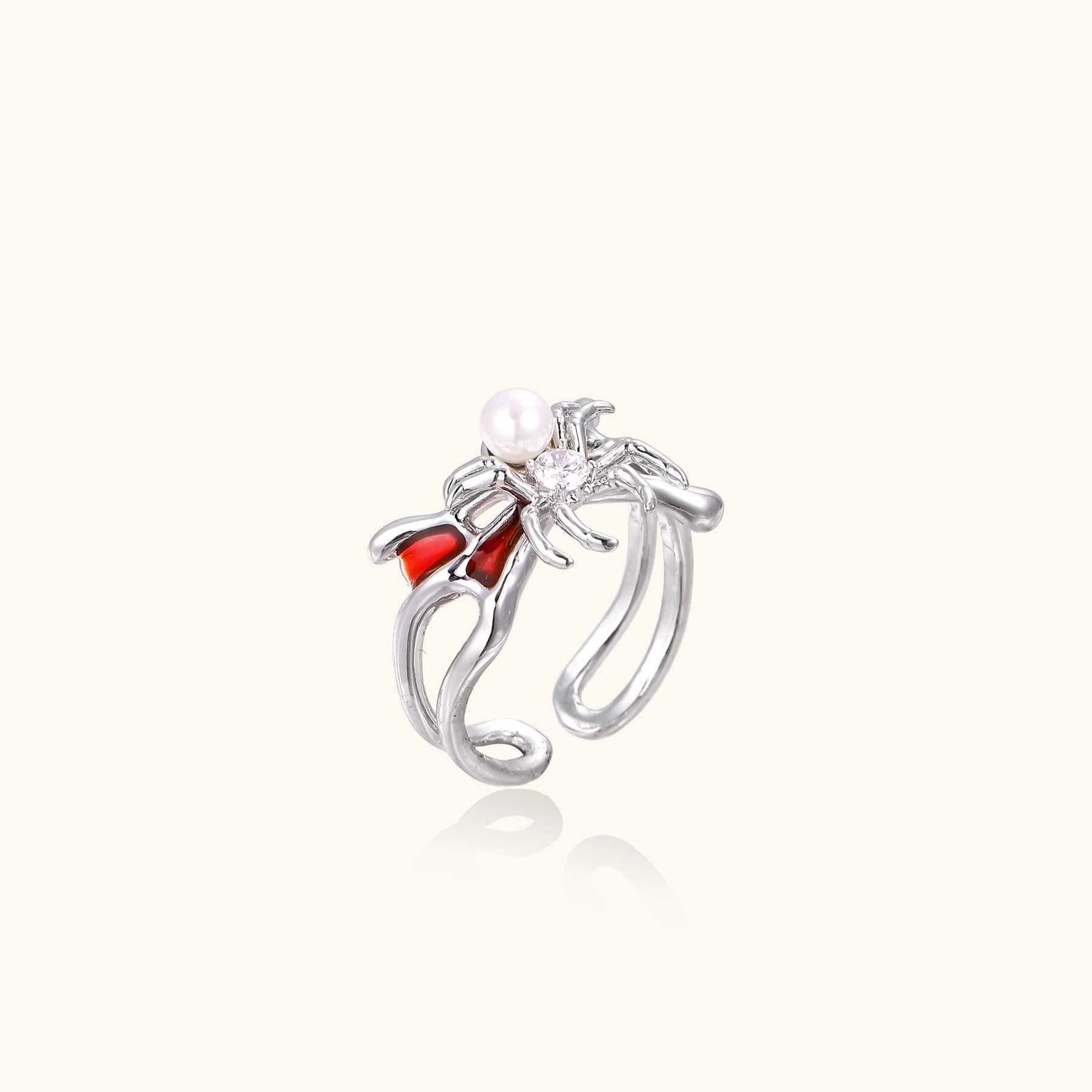 Gold-plated adjustable ring featuring spider design with white pearl, red enamel accents, and central zirconia stone