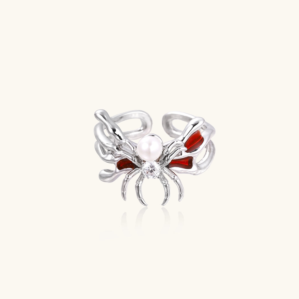 Gold-plated adjustable ring featuring spider design with white pearl, red enamel accents, and central zirconia stone