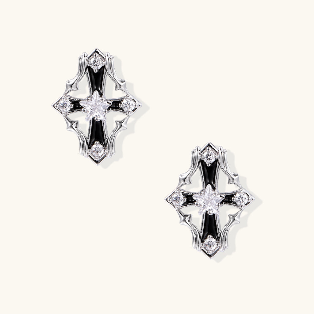 Pair of gold-plated cross earrings with clear zirconia crystals and silver posts on neutral background.