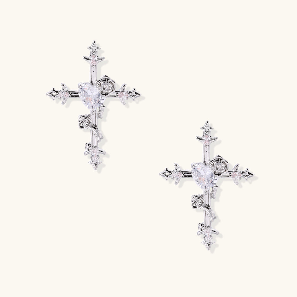 Ornate cross-shaped dangle earrings with gold roses and sparkling zirconia stars on silver-toned base with hoop closures.