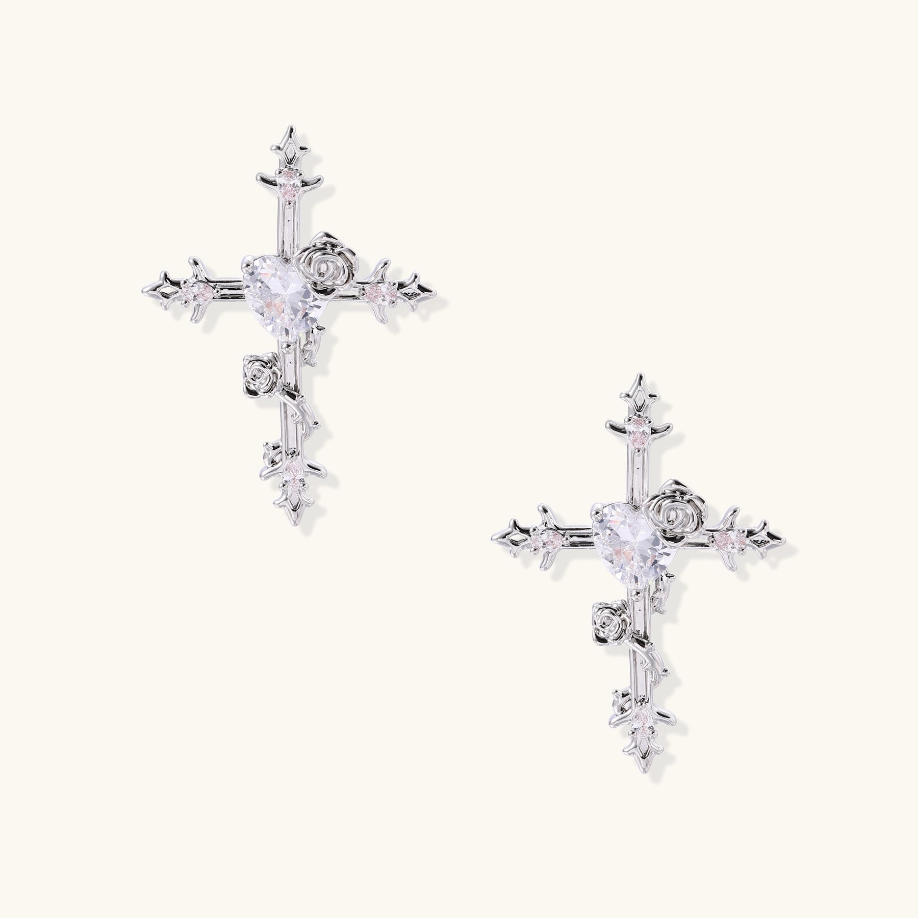 Ornate cross-shaped dangle earrings with gold roses and sparkling zirconia stars on silver-toned base with hoop closures.