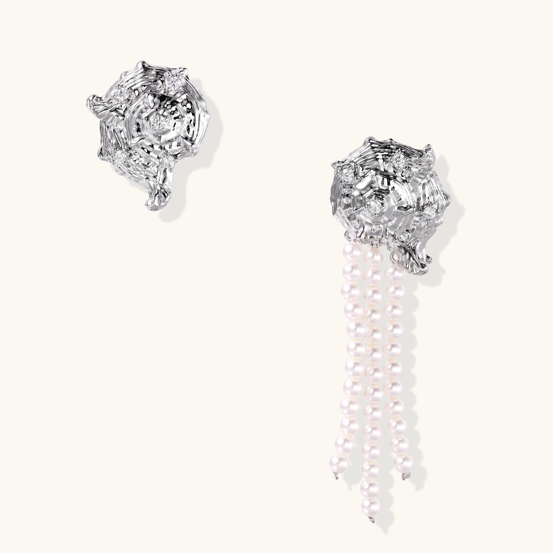 Intricate gold-plated geometric dangle earrings with zirconia stones and pearl drops on neutral background