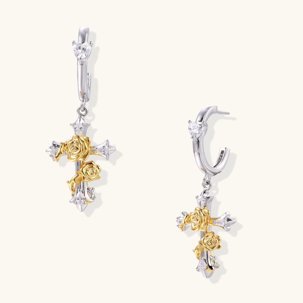 Gold-plated brass cross earrings with rose details and zirconia stones on silver hoops against light background.