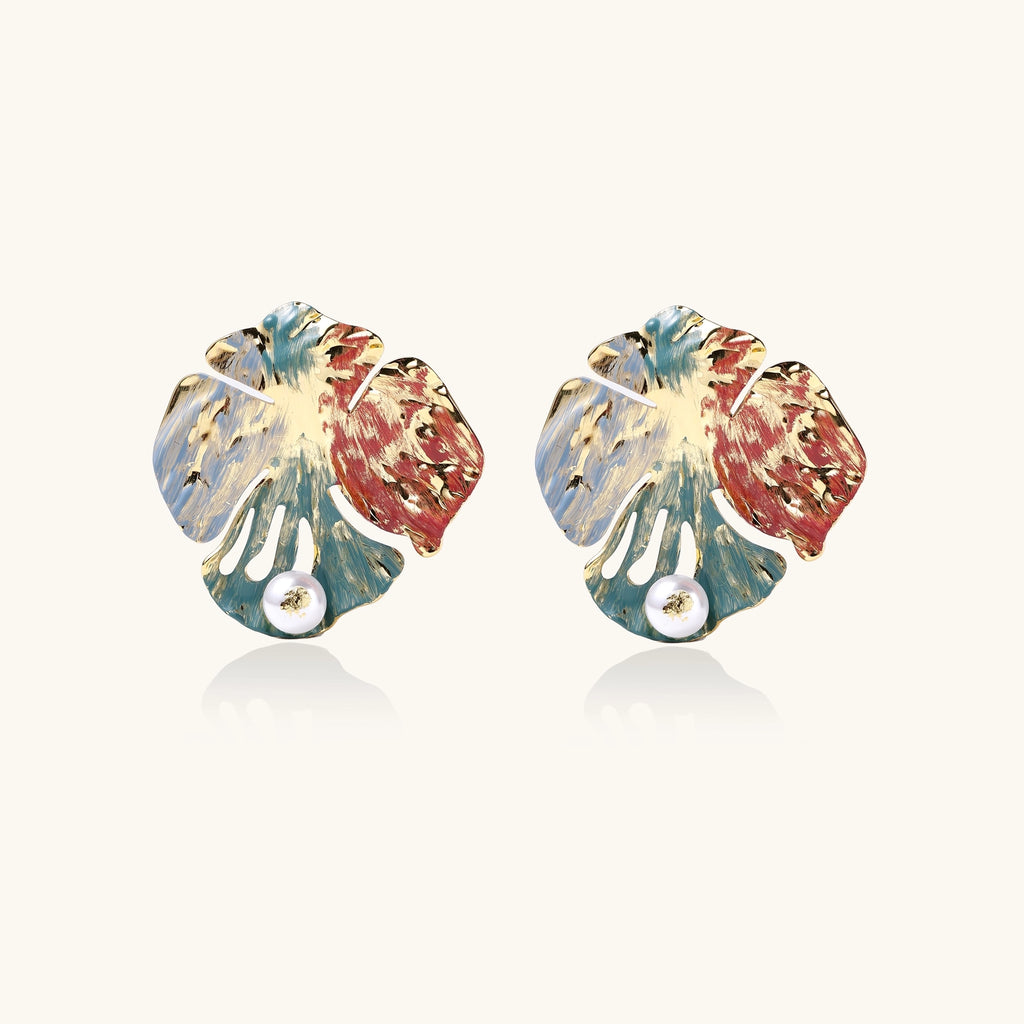 Colorful enamel monstera leaf earrings with pearl accents in teal, coral and gold tones on neutral background.