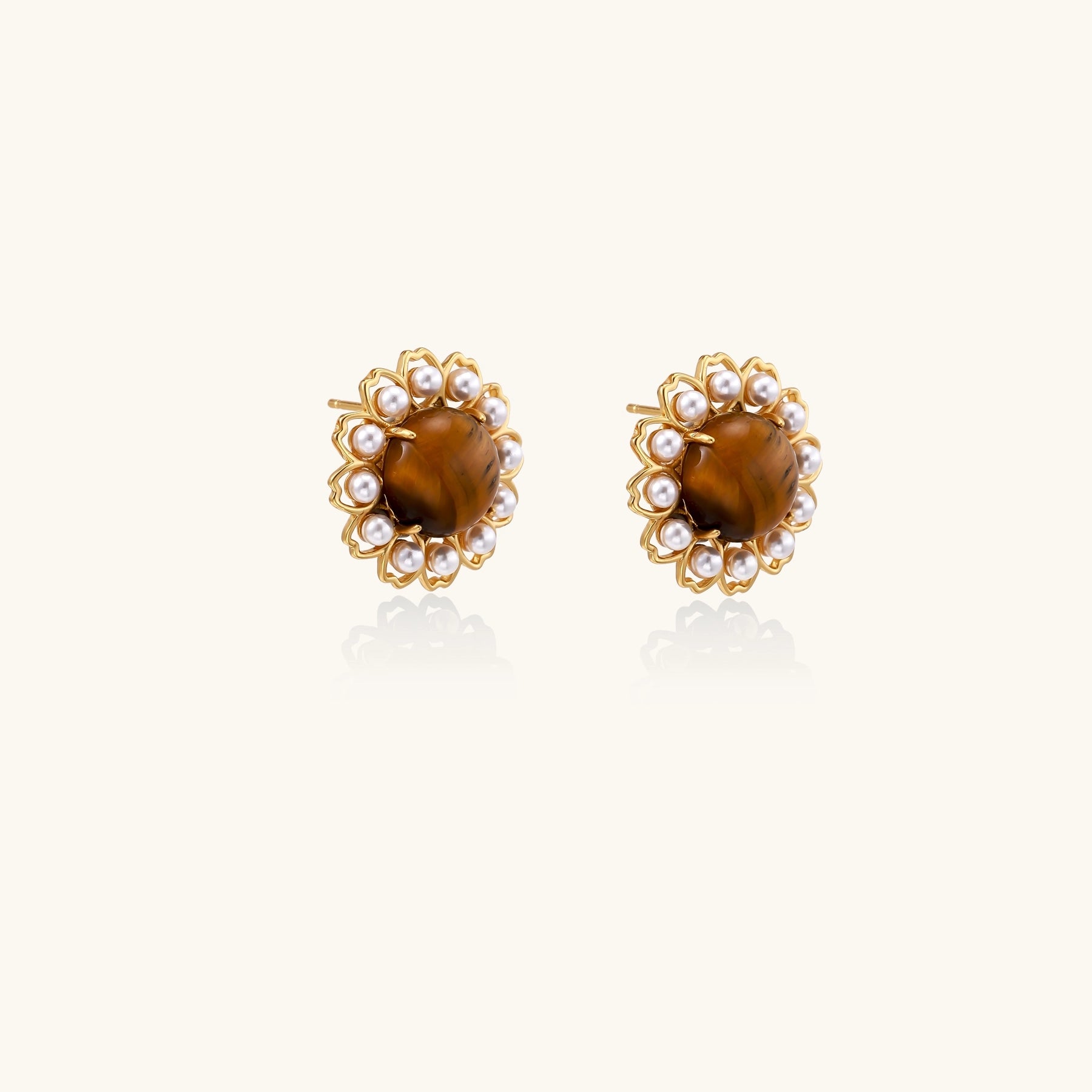 Gold-plated stud earrings with round tiger's eye stones surrounded by small pearls in a floral pattern.