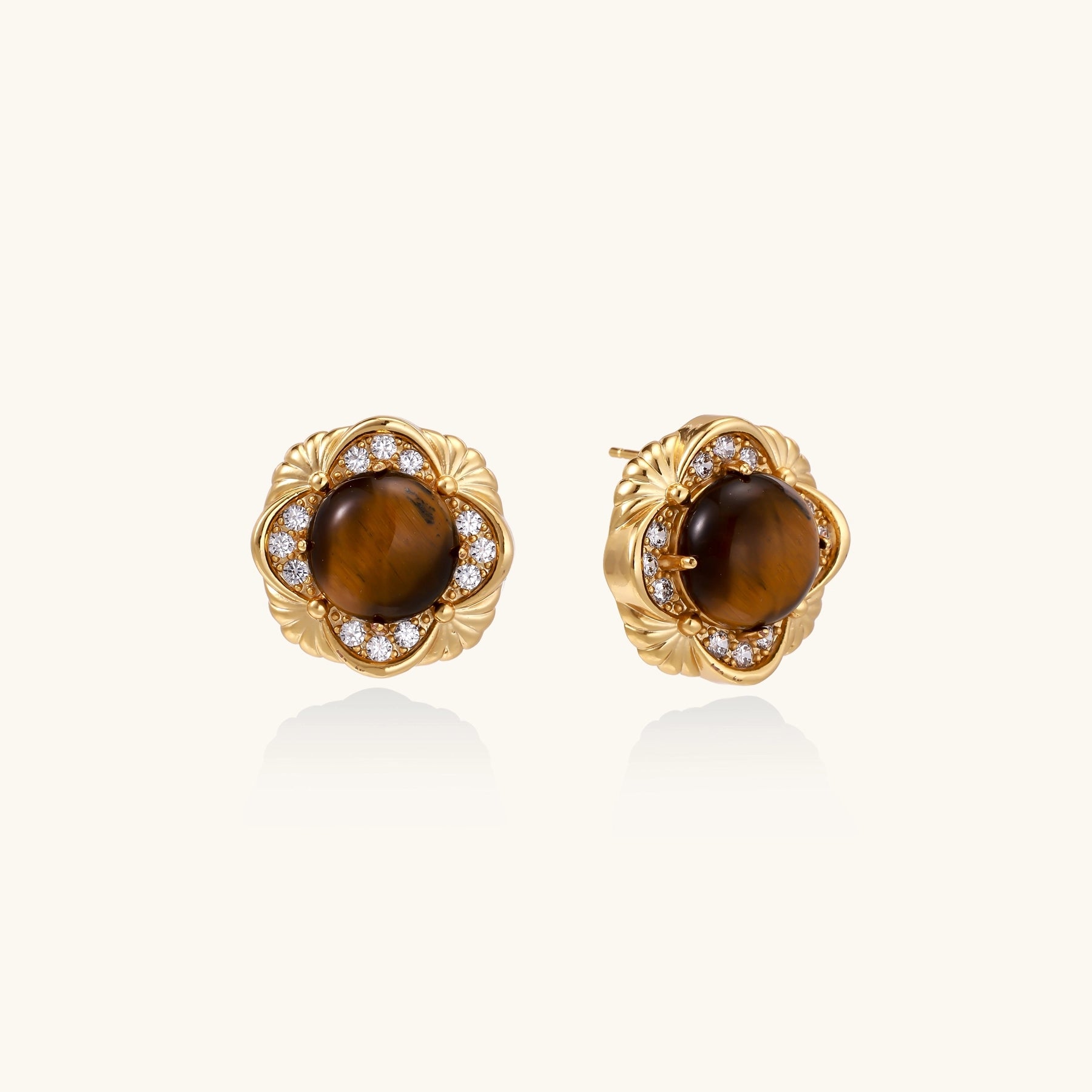 Ornate gold-plated brass stud earrings featuring round tiger's eye stones surrounded by sparkling zirconia in floral design
