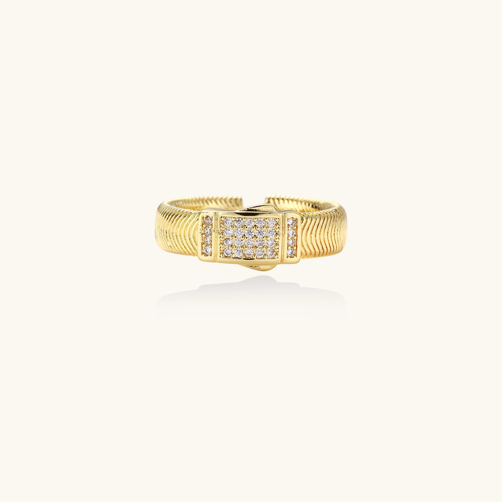 Gold-plated brass cuff ring with textured band and rectangular cubic zirconia centerpiece on cream background