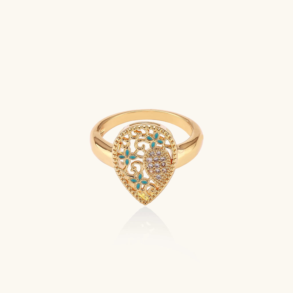 Gold-plated heart ring with turquoise enamel scrollwork and cubic zirconia stones on white background