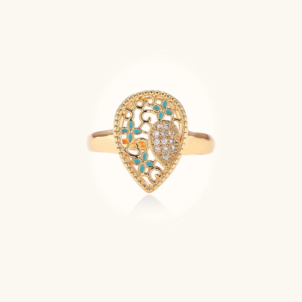 Gold-plated heart ring with turquoise enamel scrollwork and cubic zirconia stones on white background