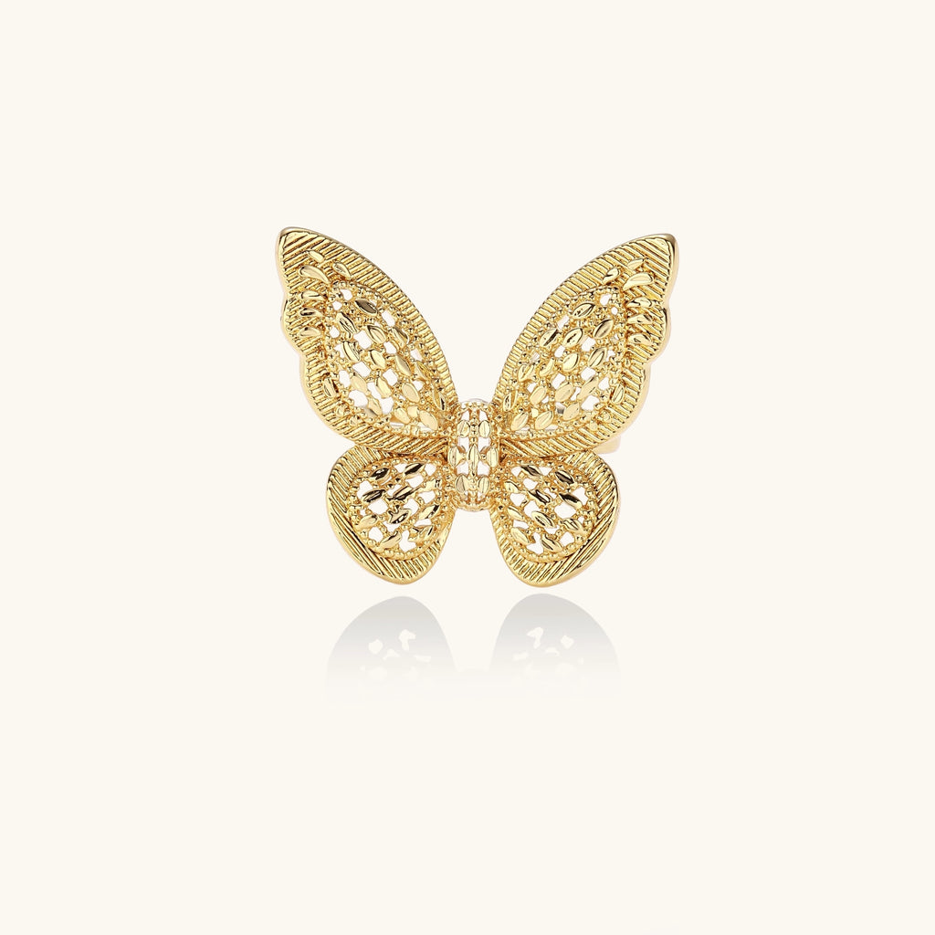 Adjustable gold-plated brass butterfly ring with intricate filigree cutout patterns and cubic zirconia accents on white background.