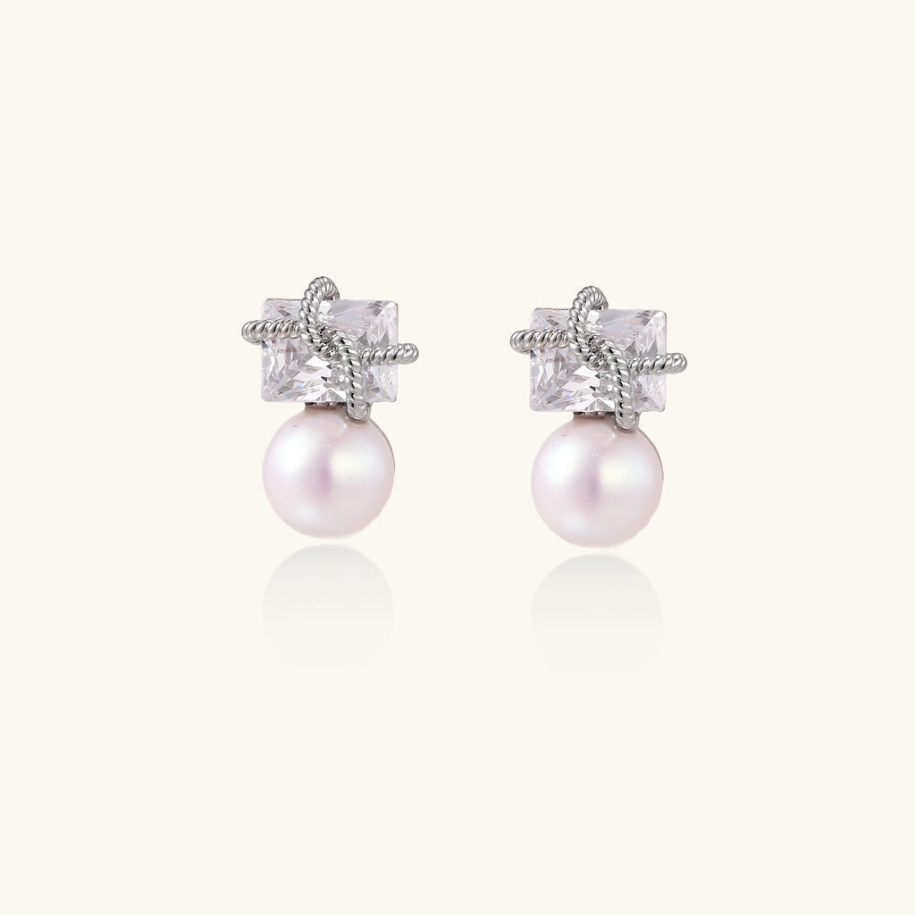 Gold-plated stud earrings with square crystal tops wrapped in twisted wire and freshwater pearl drops on white background