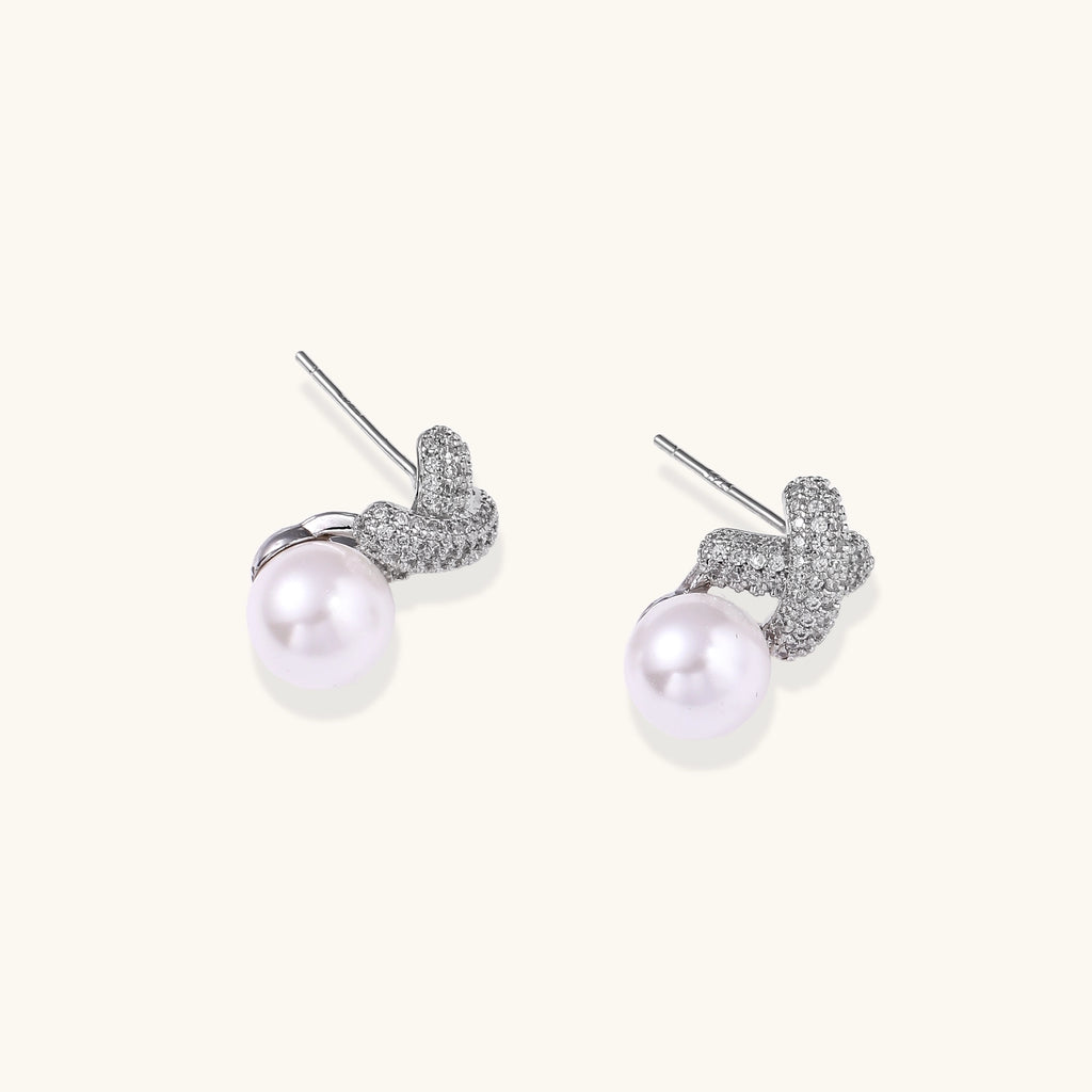 Elegant drop earrings with pavé crystal cross tops and round freshwater pearls on 14K gold plated brass setting.