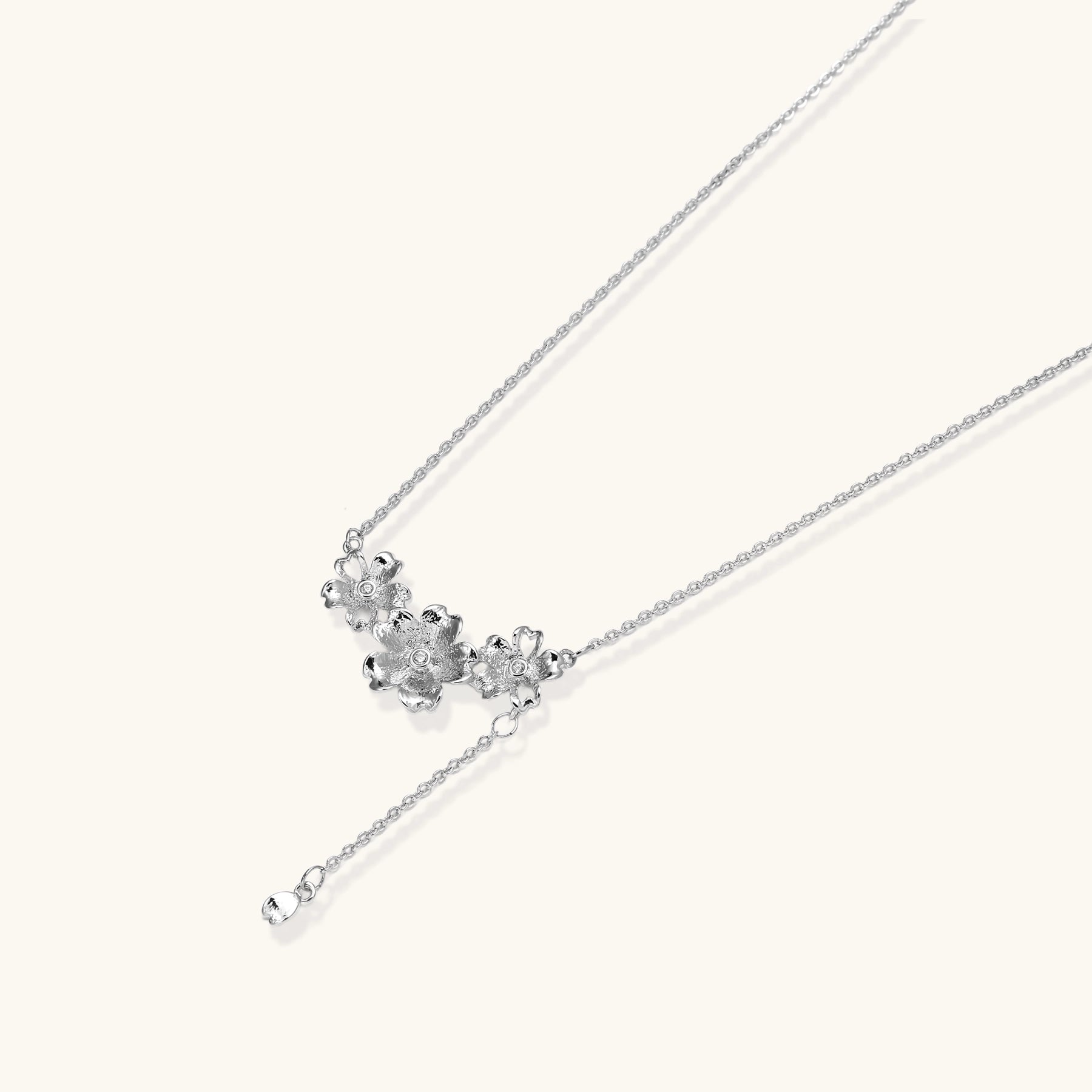 Delicate Y-style necklace with three textured flower pendants and adjustable chain in 14K gold plated brass finish.
