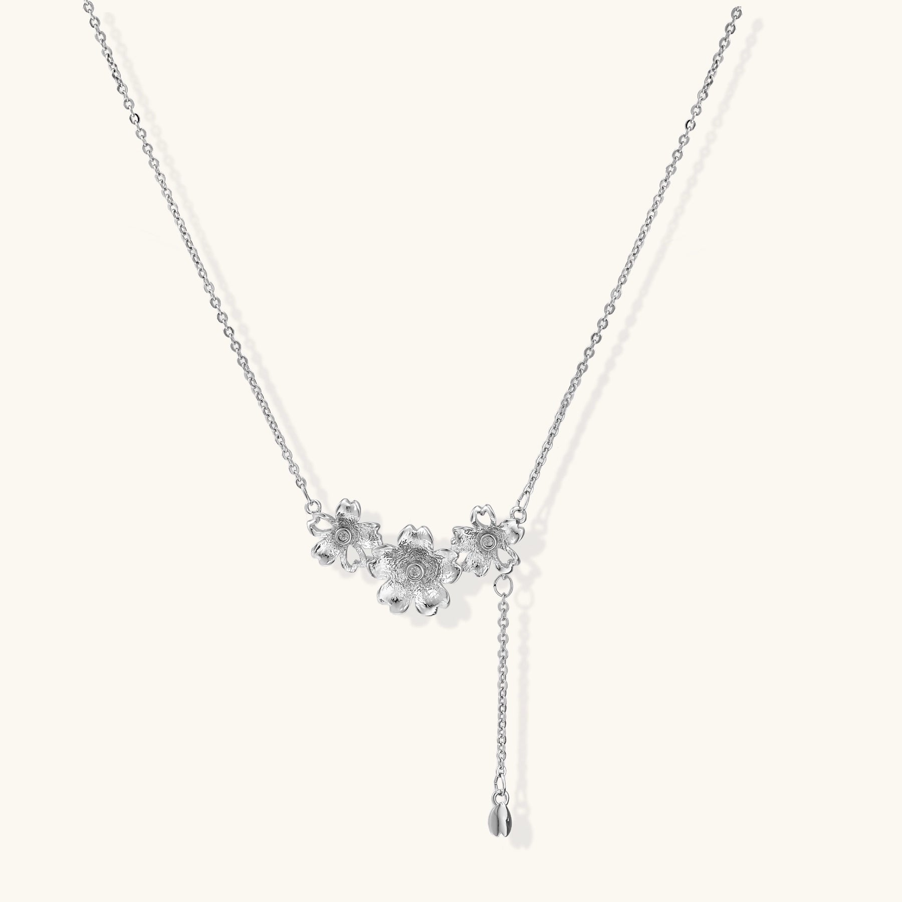 Delicate Y-style necklace with three textured flower pendants and adjustable chain in 14K gold plated brass finish.