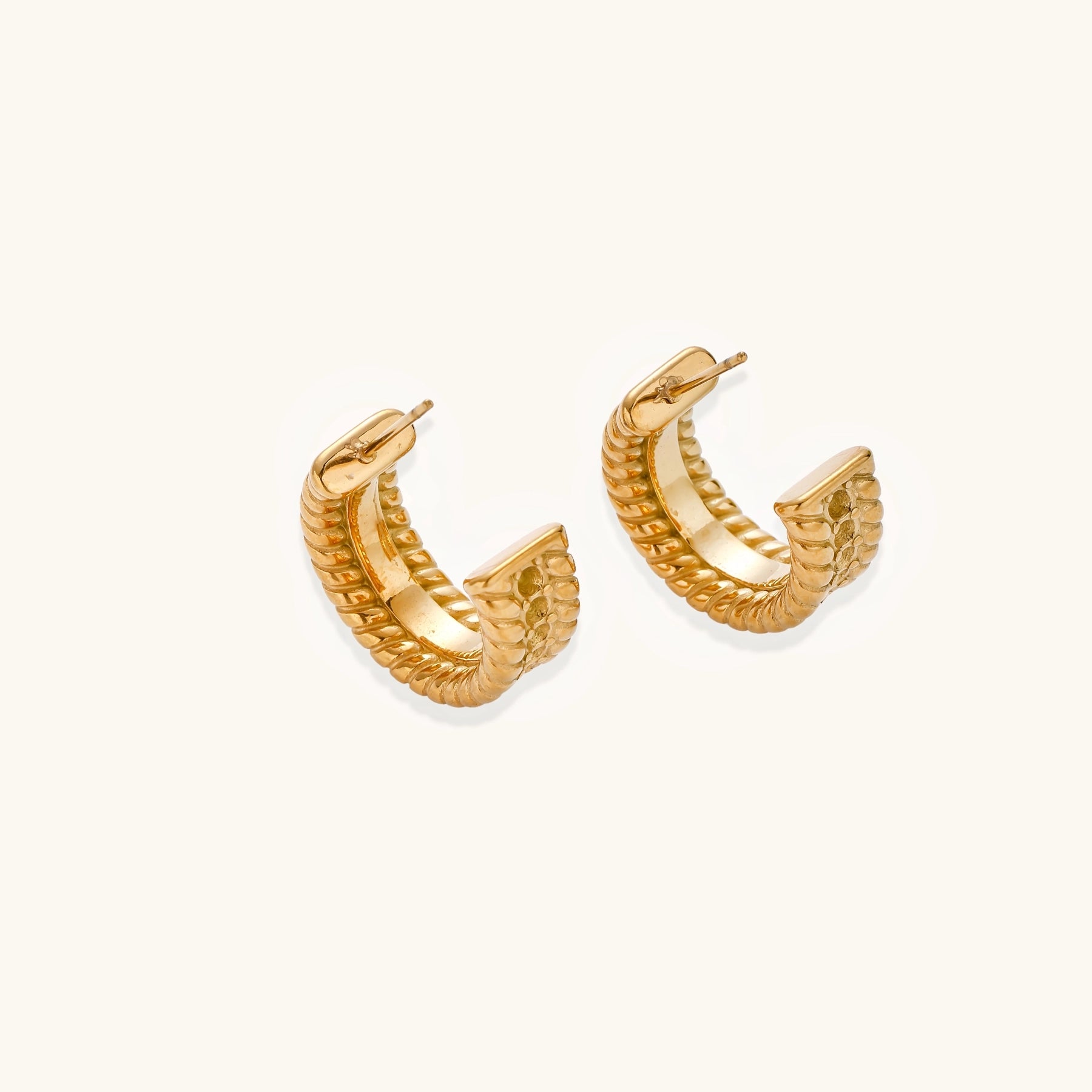 Close-up of 14K gold plated textured hoop earrings with rope pattern against cream background showing convertible design
