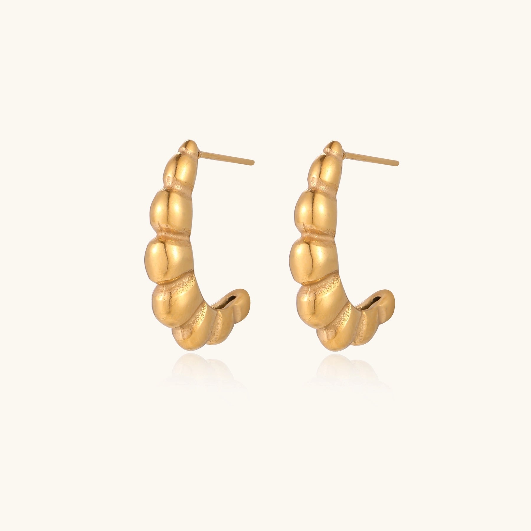 Gold-plated stainless steel hoop earrings with segmented bubble design and post closure on white background