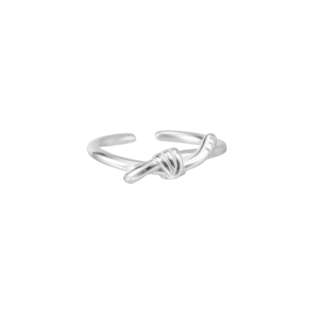 Delicate rhodium-plated silver ring with elegant knot design on cream background, adjustable band style
