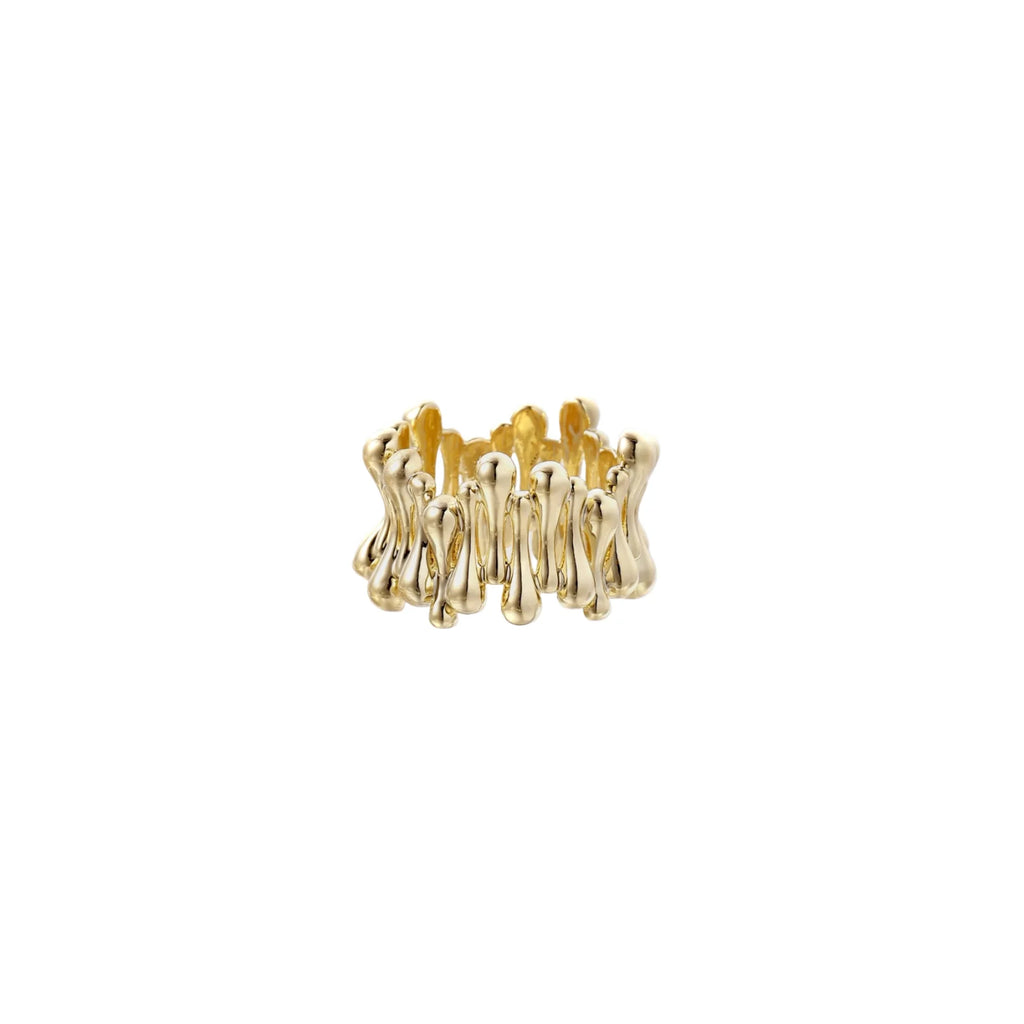 Gold-plated brass ring with sculptural petal-like elements in a wide band design on beige background
