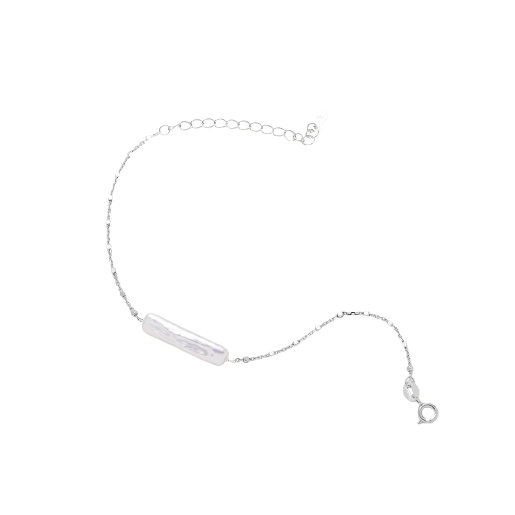 Minimalist bracelet with iridescent baroque pearl on rhodium-plated sterling silver chain against cream background
