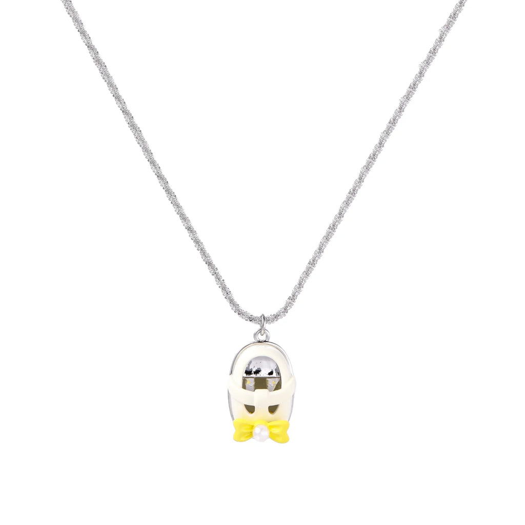 Chrome egg-shaped pendant with kawaii face, yellow bow, and pearl detail on silver chain against white background