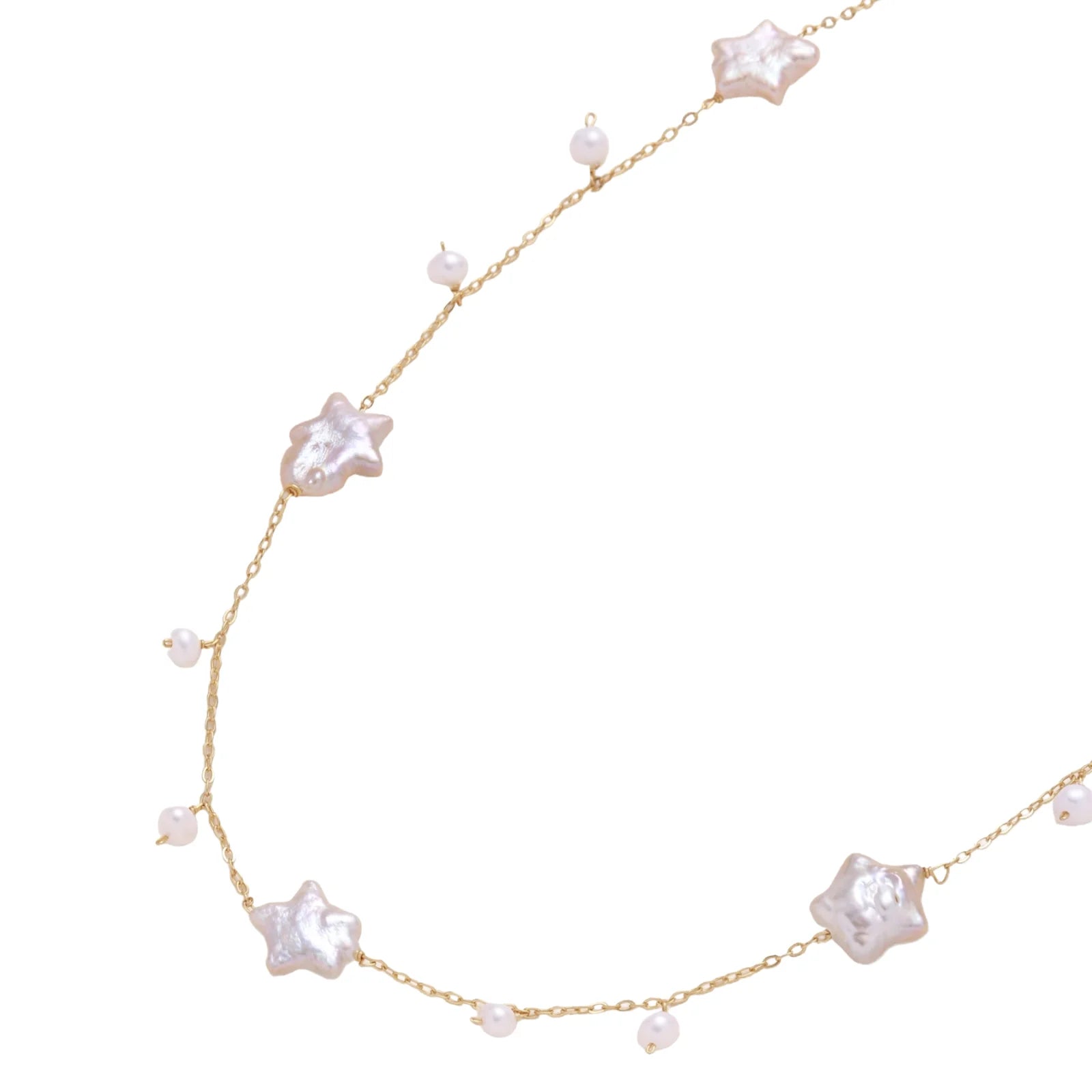Gold vermeil chain with iridescent star-shaped baroque pearls and small round freshwater pearl drops on cream background.