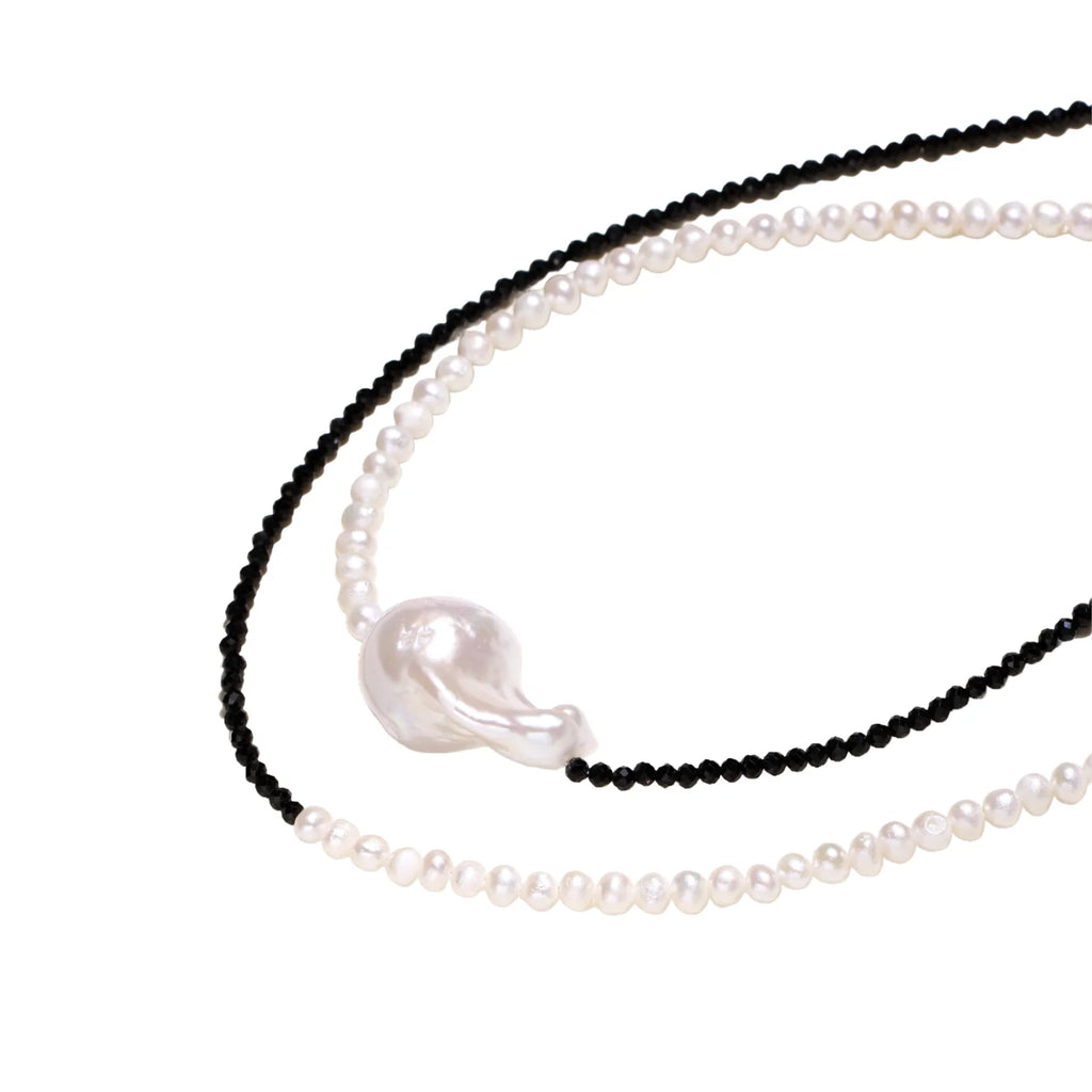 Double-strand necklace with black faceted quartz and white pearls featuring an oversized baroque pearl centerpiece