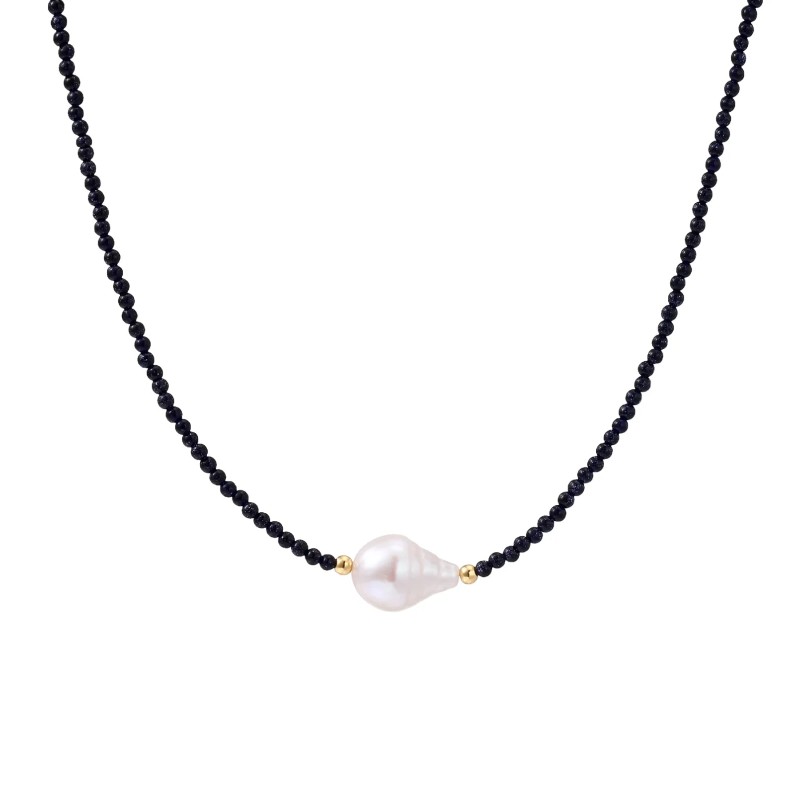 Delicate necklace with black blue sandstone beads and baroque pearl center on white background with gold accents.